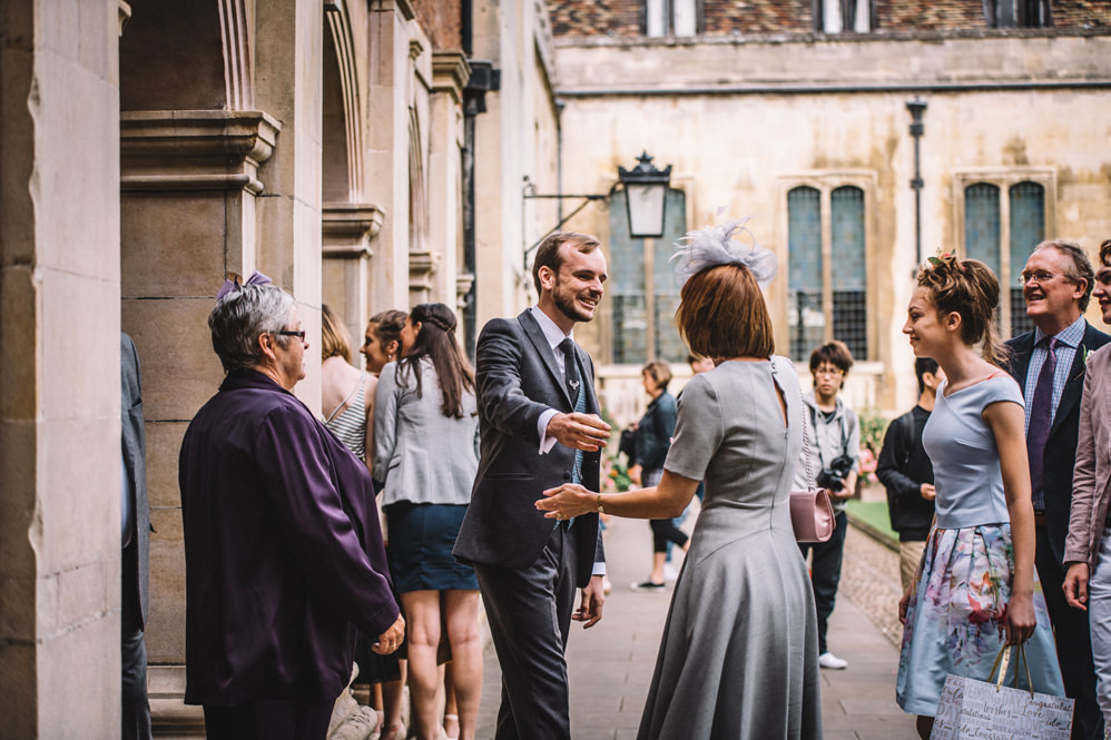 groom meeting guests at pembroke college wedding photography